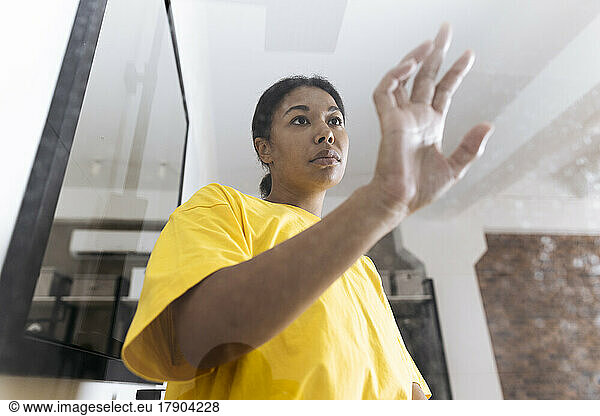 Unhappy woman touching confining glass pane