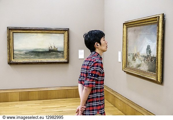 United Kingdom Great Britain England  London  Westminster  Millbank  Tate Britain art museum  inside interior  gallery  paintings  A Ship Aground Yarmouth  Shipping at the Mouth of the Thames  Asian  boy  teen  looking