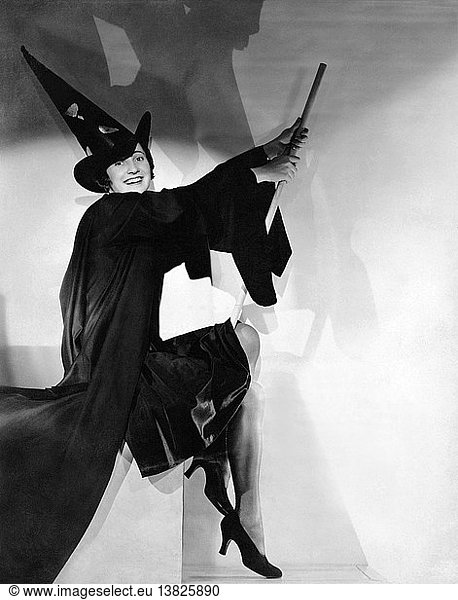 United States: c. 1930 A young woman with a broom in a witch´s costume on Halloween..