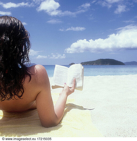 United States  United States Virgin Islands  St. John  Rear view of woman reading book on beach