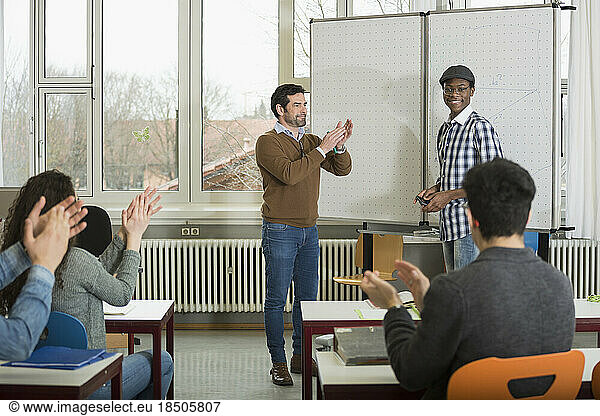 University student finishing classroom presentation  students and teacher clapping School  Bavaria  Germany