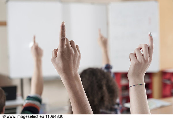 University students raising their hands in classroom  Bavaria  Germany