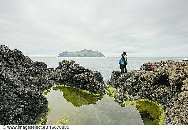 Unrecognizable couple admiring sea from cliff
