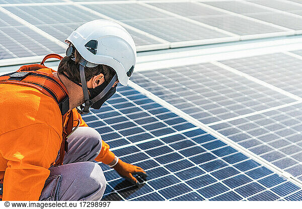 Unrecognizable solar panel technician touching a Spanish installation