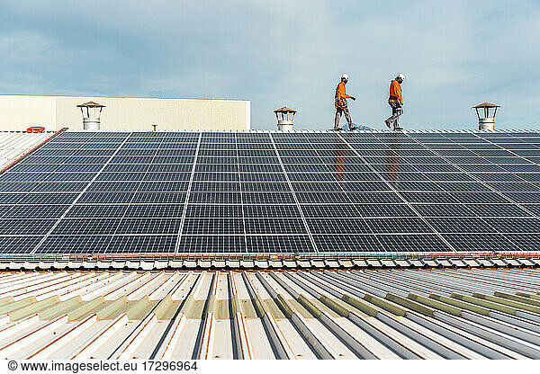 Unrecognizable solar panel technicians checking a Spanish factory