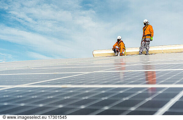 Unrecognizable solar panel technicians cheking a Spanish installation