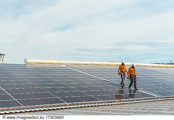 Unrecognizable solar panel technicians cheking Spanish installation