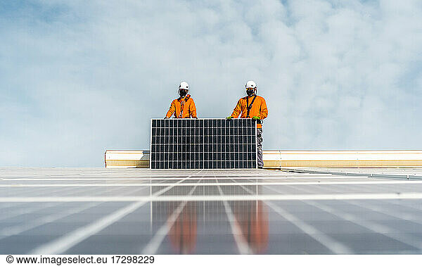 Unrecognizable solar panel technicians posing in Spanish installation