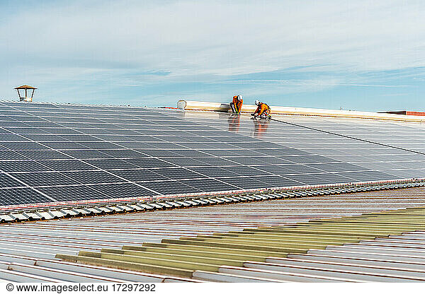 Unrecognizable solar panel technicians working a Spanish factory
