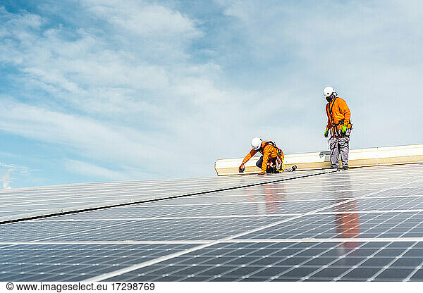 Unrecognizable solar panel technicians working in Spanish installation