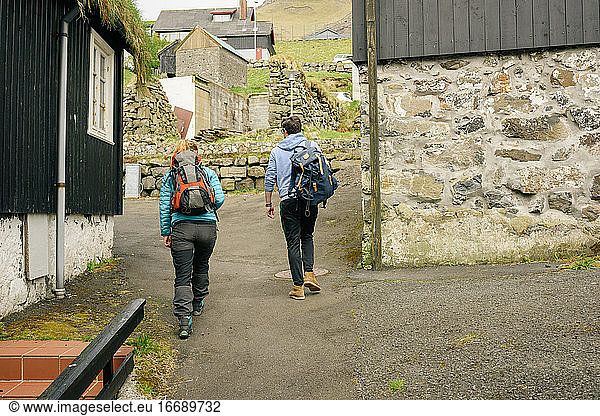 Unrecognizable travelers walking in village
