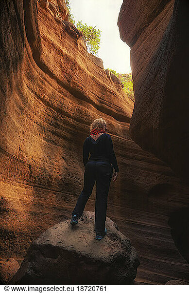 unrecognizable woman with her back to the sky  inside a canyon