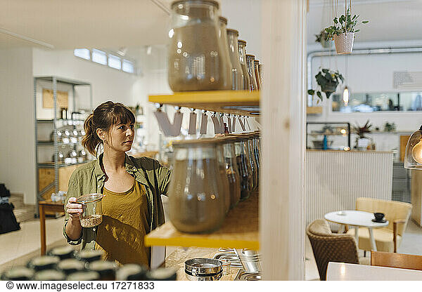 Unternehmerin arrangiert Glasgefäß in Café