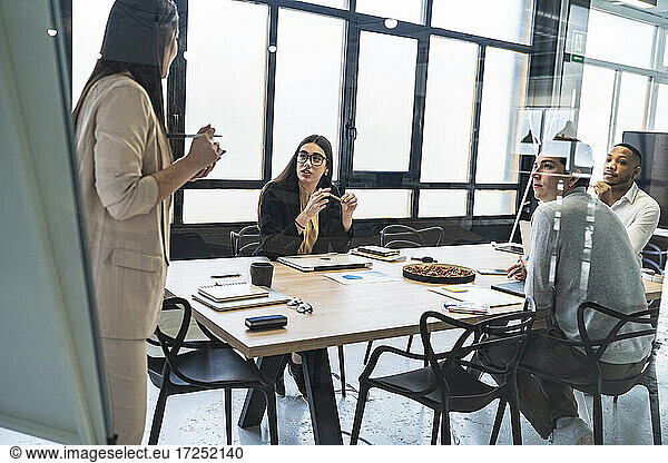 Unternehmerin im Gespräch mit männlichen und weiblichen Unternehmern bei einem Treffen im Coworking-Büro