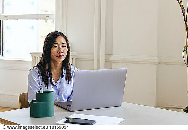 Unternehmerin mit Laptop auf dem Schreibtisch im Kreativbüro
