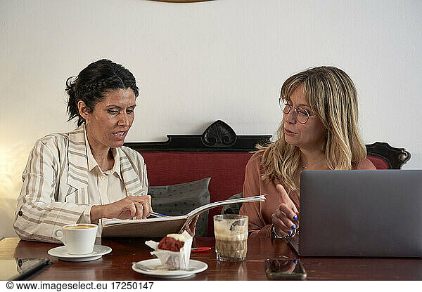 Unternehmerinnen diskutieren in der Cafeteria über Strategien