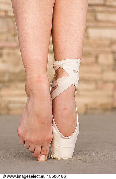 Up close of ballet dancer's feet on pointe. One shoe on  one off.