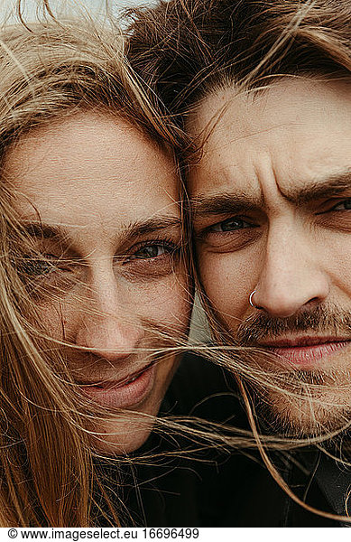 up close of man and woman with eyes next to each other and windy hair