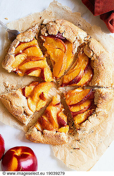 Up close shot of freshly baked nectarine galette sliced into pieces