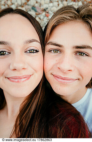 up close view of teen boy face and teen girl face filling the frame