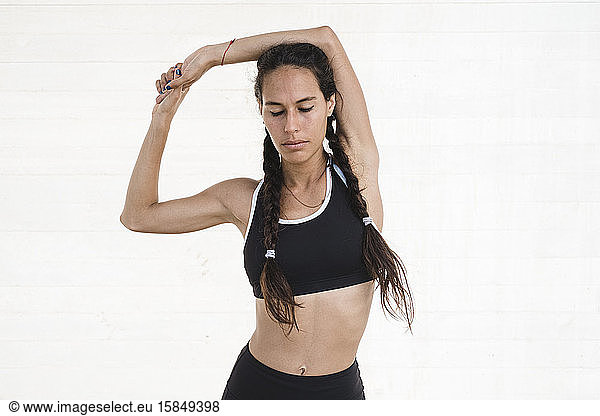 Upper body of female athlete stretching arms