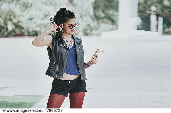 Urban girl listening to music with headphones outdoors