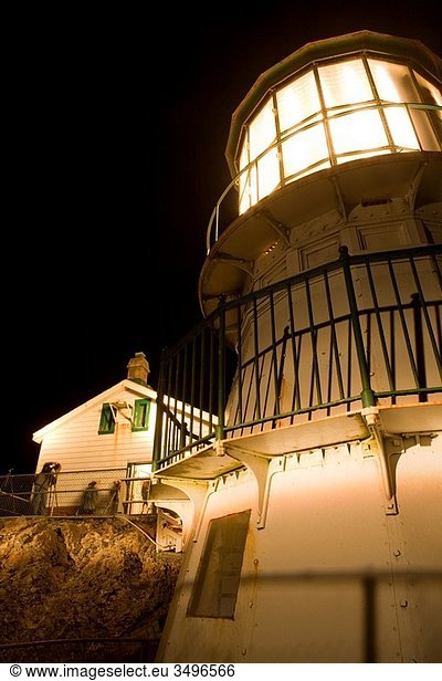 USA  California  Marin County  Point Reyes National Seashore  old lighthouse perched on point of Point Reyes Conglomerate rock  amateur photographers taking pictures  night  vertical