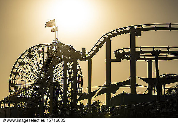 USA  California  Santa Monica  Silhouettes of Ferris wheel and rollercoaster of Santa Monica Pier at sunset