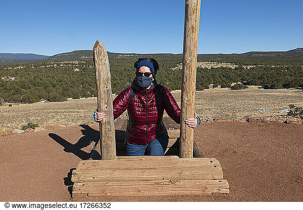 USA  New Mexico  Pecos  Frau mit Gesichtsmaske klettert aus einem Lagerschuppen im Pecos National Historical Park