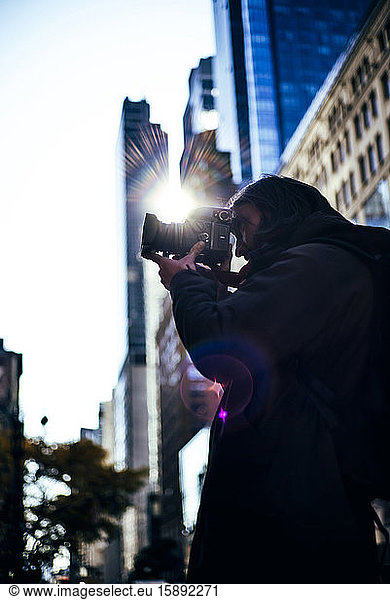 USA  New York City  Junger Mann beim Fotografieren mit seiner Kamera