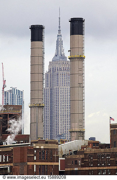 USA  New York  New York City  Empire State Building seen between two factory chimneys