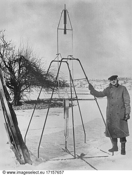 USA -- 1926 -- Robert H. Goddard neben einer Rakete mit Flüssigtreibstoff aus dem Jahr 1926. Die Rakete befindet sich oben und erhält ihren Treibstoff über zwei Leitungen aus dem unteren Tank. Goddards Raketen beeindruckten die Regierungsbeamten nur wenig  obwohl er praktisch die moderne NASA gründete und als Pionier der Raumfahrt gilt  der die Raketentechnologie nutzte  die später im Zweiten Weltkrieg entwickelt wurde -- Bild von Lightroom Photos / USAF ***NB Nicht auf Staub und Kratzer retuschiert.