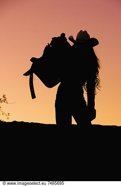 USA  Texas  Cowgirl holding saddle