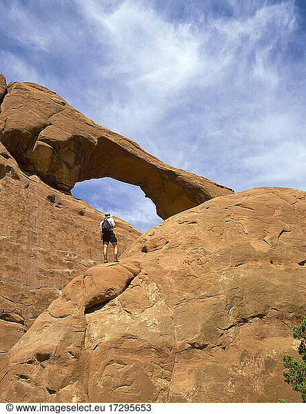 USA  Utah  Arches National Park  Rückansicht eines Mannes mit Blick auf einen Felsbogen