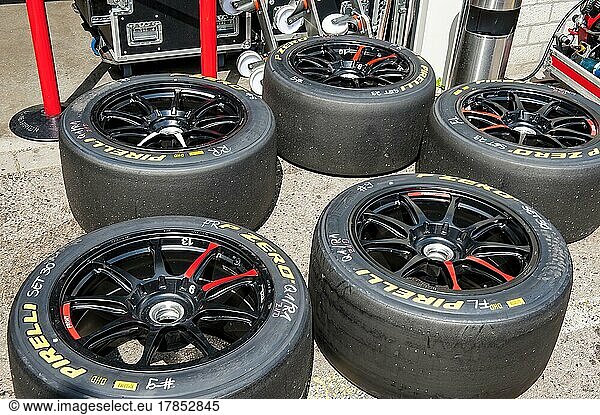 Used Pirelli racing tyres slicks on rim with central lock lie on ground in front of pit lane after tyre change during car race  Circuit Zandvoort  province North Holland  Netherlands