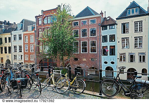 UTRECHT  NIEDERLANDE  25. MAI 2018: Fahrräder  die ein sehr beliebtes Transportmittel in den Niederlanden sind  parken in der Straße entlang des Kanals in der Nähe alter Häuser. Utrecht  Niederlande  Europa