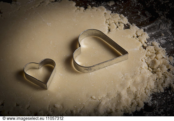 Valentine's Day baking,  heart shaped biscuit cutters on dough.