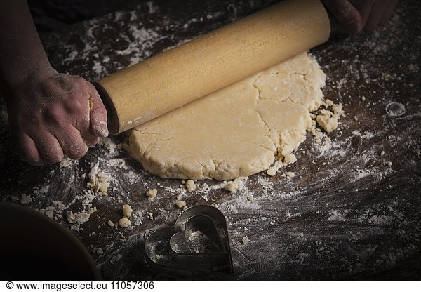 Valentine's Day baking,  woman rolling out dough with a rolling pin.