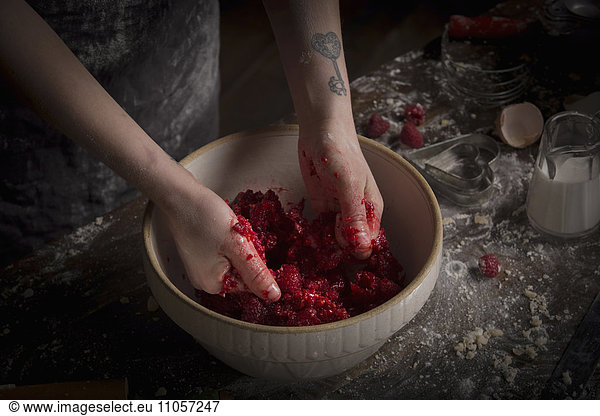 Valentine's Day baking  woman preparing fresh raspberries in a bowl.