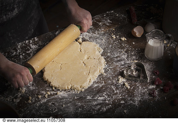 Valentine's Day baking  woman rolling out dough with a rolling pin.