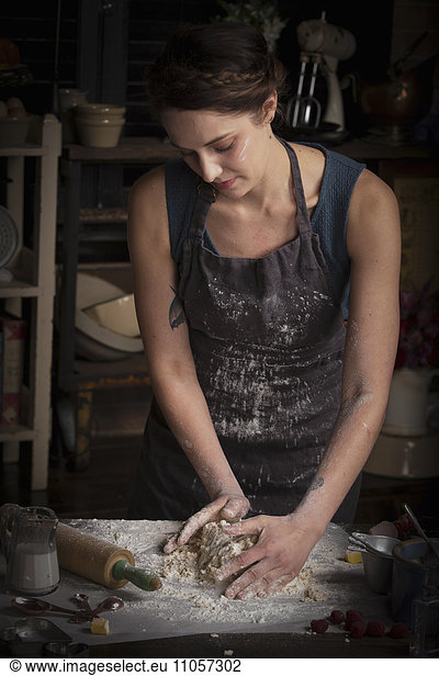 Valentine's Day baking  woman standing in a kitchen  preparing dough for biscuits.