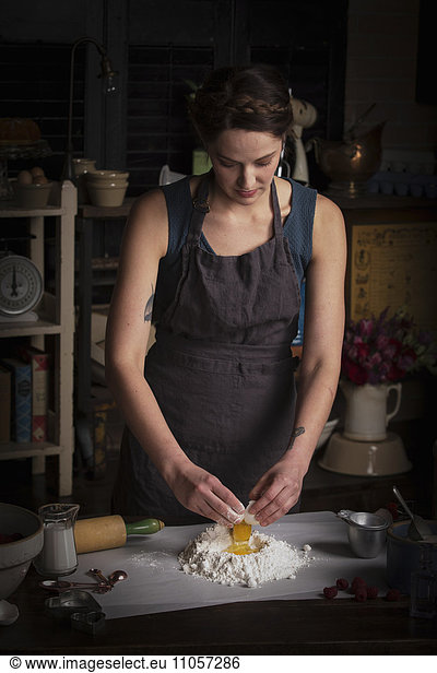 Valentine's Day baking  young woman standing in a kitchen  preparing dough for biscuits.