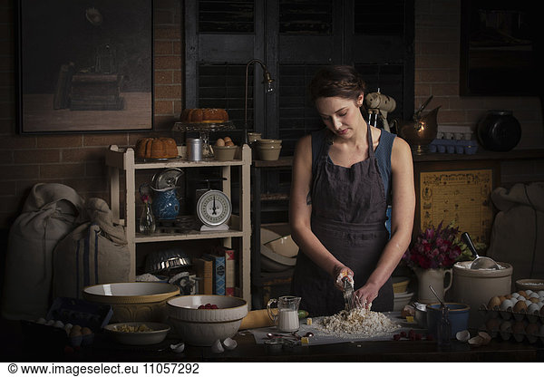 Valentine's Day baking  young woman standing in a kitchen  preparing dough for biscuits.