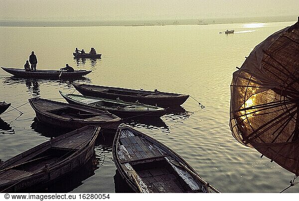 Varanasi (Benares)  Uttar Pradesh  India  Asia - Daybreak with sunrise over wooden rowboats at the bank along the holy Ganges river.