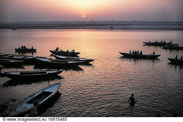 Varanasi  Uttar Pradesh  India  Asia - Daybreak with sunrise over wooden rowboats at a ghat on the bank along the holy Ganges River.