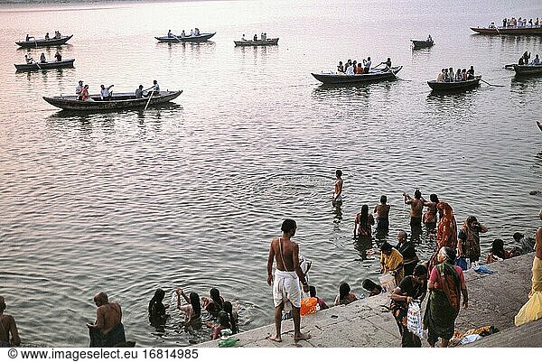 Varanasi  Uttar Pradesh  Indien  Asien - Blick von einem Ghat am Ufer des heiligen Ganges auf die im Fluss badenden Menschen und die vorbeifahrenden Ruderboote im Hintergrund.