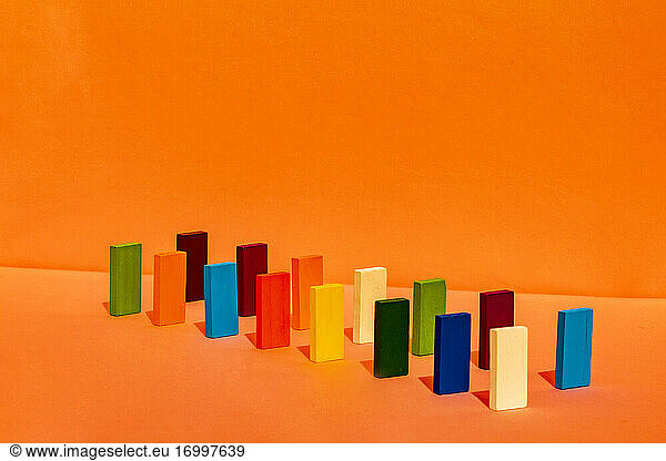 Variation of rectangular construction blocks arranged in a line on orange background