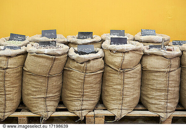 Varieties of cereals and seeds in sack at store by wall