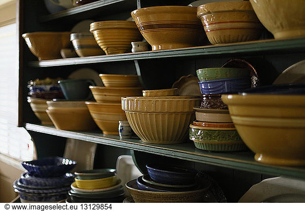 Various bowls arranged on shelves in kitchen