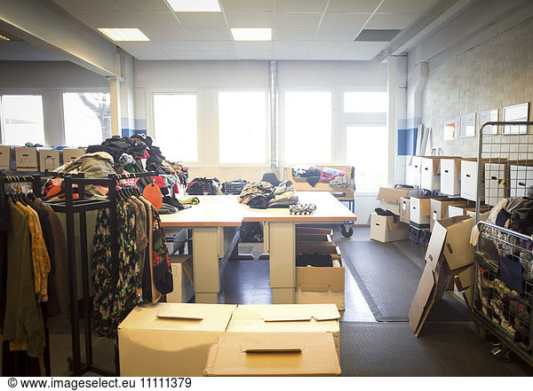 Various clothes and objects with boxes in brightly lit workshop
